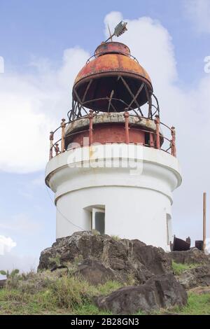 Vecchio faro su una massa rocciosa con erba verde sotto cielo nuvoloso blu, istituito nel 1912.730 piedi sopra il livello del mare, Moule-a-chique Vieux-Fort Foto Stock