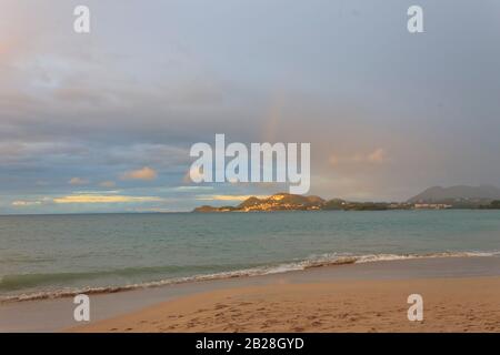 Bellissimo arcobaleno in un cielo panoramico vera bellezza nella natura in un giorno in cui il cielo è stato coperto a Vigie Beach nella tropicale Santa Lucia Foto Stock