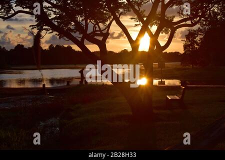 SUL MOLO: Questa serie di foto narra un uomo anziano che pesca durante il giorno prendendo in un tramonto della Florida nella relativa conclusione. Foto Stock