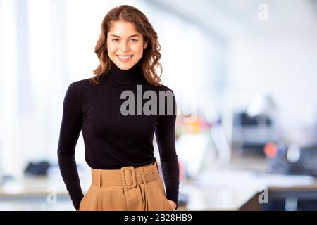 Attacive giovane donna d'affari ritratto mentre guardando la fotocamera e sorridente. Isolato su sfondo bianco. Foto Stock