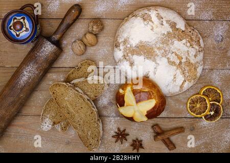 Pane fresco e fette di pane su tavole di legno con pane a spina di laminazione in stile retrò, noci e spezie. Vista dall'alto, brochure e banner per groc Foto Stock