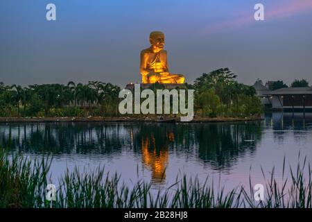 Luang pu Tuad (l'enorme Buddha d'oro) dopo il tramonto dal lago, Ban mai, Maha Rat District, Phra Nakhon si Ayutthaya, Thailandia. Foto Stock