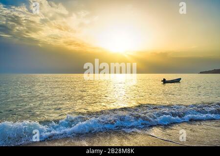 Pesca barca vuota accogliente mattina luce del sole sulla spiaggia. Le onde Si Infrangono nell'ora d'oro. Da Muscat, Oman. Foto Stock