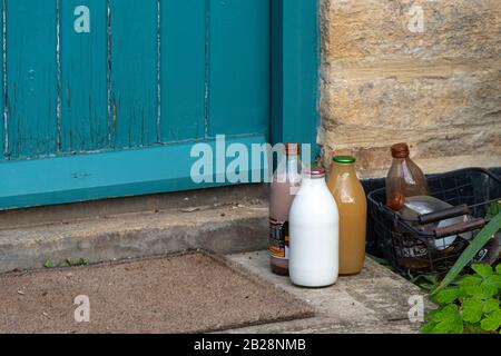 Bottiglie di latte e succo a portata di mano, Snowshill, Gloucestershire, Cotswolds, Inghilterra Foto Stock