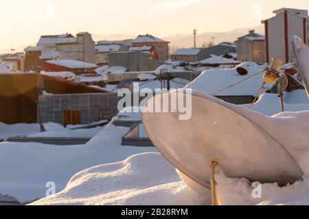 Comunicazione piatti su tetti innevati in inverno, problema nella ricezione di segnali a maltempo Foto Stock