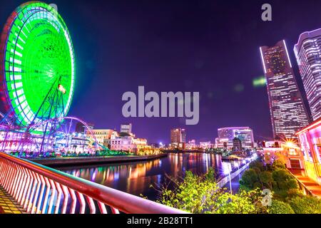 Scena notturna del paesaggio urbano di Yokohama, Giappone. Ruota panoramica, Corniche, skyline fronte mare con edifici Yokohama e grattacieli del quartiere Minato Mirai Foto Stock
