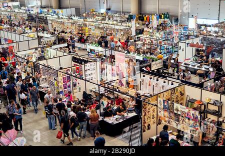 Persone a piedi intorno alle bancarelle del festival DEI ROMICI affollato (Rome Comics), due volte l'anno l'iconico raduno e mercato di Cosplay, amanti del fumetto Foto Stock