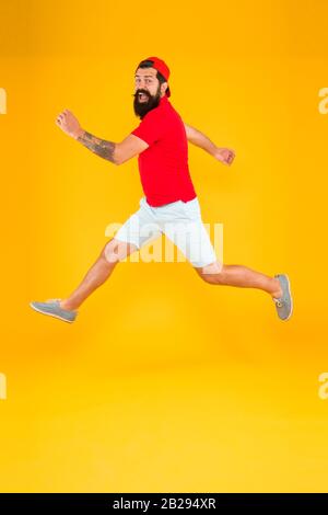 Sempre in movimento. Uno stile di vita attivo. Felice ragazzo che salta. Uomo con bearded attivo in movimento sfondo giallo. Hippster attivo ed energetico. Carica di energia. Sano ragazzo sentirsi bene. Concetto ispirato. Foto Stock