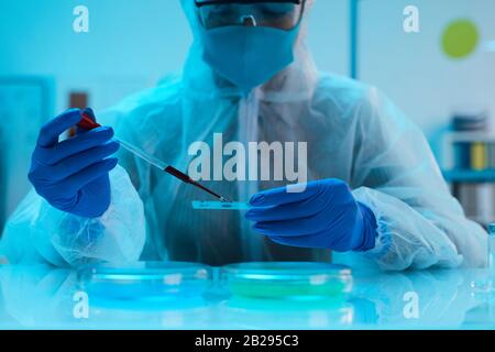 Ritratto dello scienziato che esamina il campione di sangue in laboratorio medico mentre fa ricerca, copia spazio Foto Stock