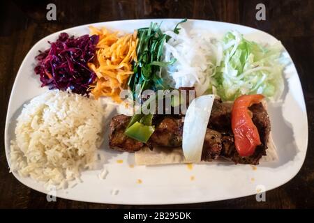 Un pasto di agnello grigliato con riso e insalata, cucina turca servita in un ristorante. Foto Stock