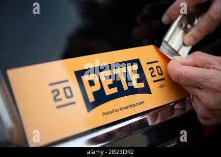 Un sostenitore di Buttigieg a Portland, Oregon, rimuove l'adesivo del paraurti 'Pete 2020' dalla sua auto. Il candidato democratico alla presidenza Pete Buttigieg sta annunciando che sta uscendo dalla gara. Il sindaco di South Bend, Indiana, non è stato in grado di sostenere i suoi sforzi di campagna andando in Super Martedì. Buttigieg è stato il primo candidato apertamente gay da un grande partito a cercare il più alto ufficio della nazione. Foto Stock