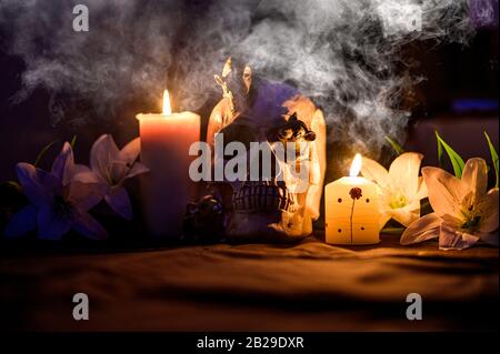 Halloween cranio nel buio circondato da fumo da candele Foto Stock