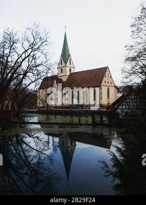 Riflesso dell'Abbazia di Blaubeuren visto nel Blautopf Foto Stock