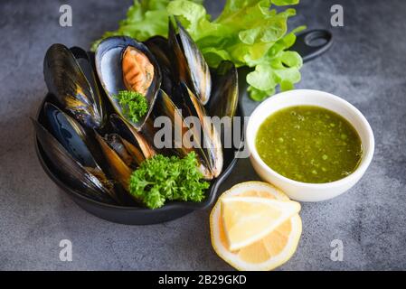 Cozze con erbe limone su cuoco cottura cottura cottura cottura cibo fondo / Frutti Di mare Fresco frutti di mare nel ristorante coussel shell cibo su pan Foto Stock