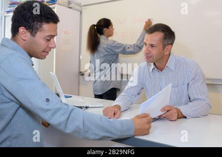 insegnante in attesa di risposta da studente maschile Foto Stock