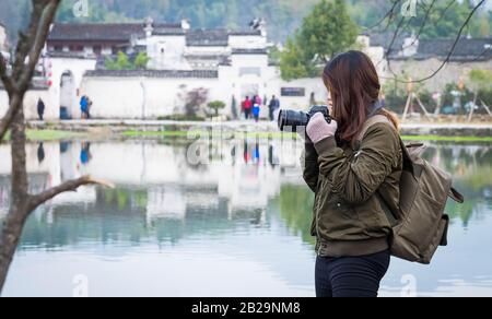 Hongcun, ANHUI/CINA - 14 GENNAIO 2020: La donna Non Specifica che scatta la foto dell'antico villaggio di Hongcun. Questo è uno dei herita del mondo unesco Foto Stock