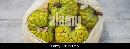 Cherimoya in una borsa riutilizzabile su un'elegante superficie in legno della cucina. Concetto di zero sprechi, concetto di plastica libera. Dieta sana e pulita e disintossicazione. Estate Foto Stock