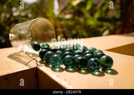 Sfera singola in marmo verde di vetro con una bella ombra e una luce impressionante con sfondo sfocato Foto Stock