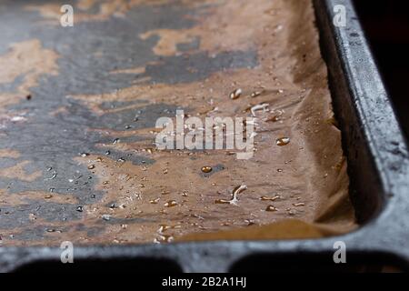 Primo piano di carta da forno grassa che si posa su un vassoio da forno Foto Stock
