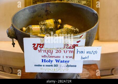 Bottiglie di 'acqua Santa' in vendita in un tempio buddista per turisti e visitatori, Bangkok, Thailandia Foto Stock