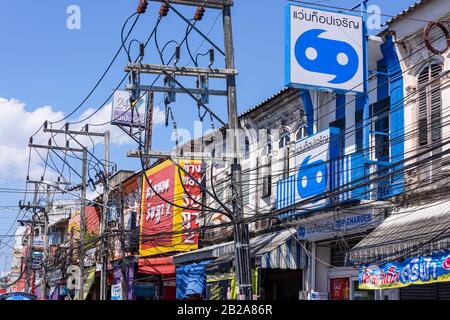 Cavi elettrici disordinati e disordinati appesi a un polo elettrico, Phuket, Thailandia Foto Stock