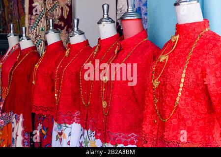 Serre tradizionali di seta rossa presso un negozio di abbigliamento femminile, Phuket Old Town, Thailandia Foto Stock