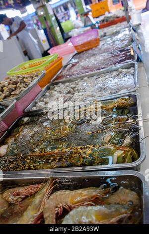 Gamberi, vongole, calamari e altri molluschi in vendita presso una stalla di pescatori nel tradizionale mercato Fresco di Mae Somchit Kata, Kata, Phuket, Thailandia Foto Stock