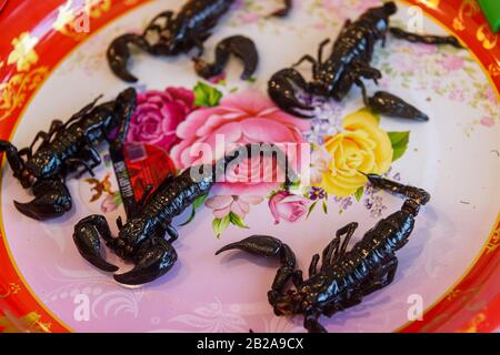 Piatto di scorpioni fritti in vendita in una stalla tailandese mercato alimentare Street, Phuket, Thailandia Foto Stock