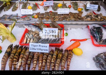 Grandi gamberi tigre, pesce, crostacei, aragoste, granchi su ghiaccio per la vendita in una stalla alimentare di strada a Phuket, Thailandia Foto Stock