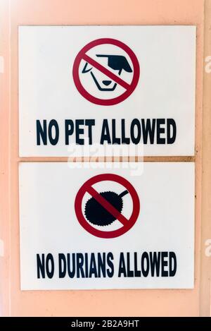 Segnali all'ingresso di un hotel avvisano gli ospiti che animali domestici e frutta Durian non sono ammessi, Thailandia Foto Stock