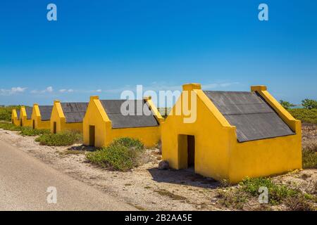 Fila di case slave gialle sulla costa di Bonaire Foto Stock