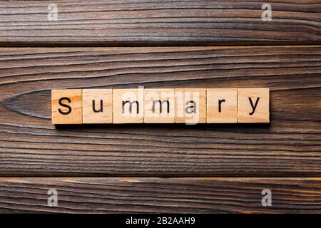 Sommario parola scritta sul blocco di legno. Il testo di riepilogo sulla tabella, concetto. Foto Stock