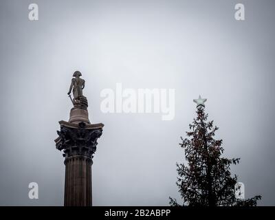 La Colonna di Nelson accanto ad un albero di Natale, Londra, Inghilterra, Regno Unito Foto Stock
