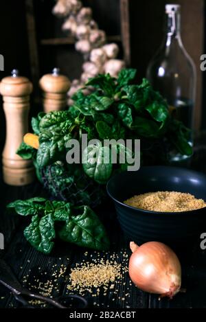 Spinaci, cipolla, aglio e grano saraceno su un tavolo di legno Foto Stock