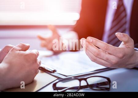 Uomini d'affari che negoziano un contratto. Mani umane che lavorano con i documenti alla scrivania e firmano il contratto. Foto Stock