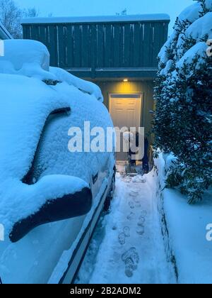 Donna che sgombrava la neve dal suo vialetto, Canada Foto Stock