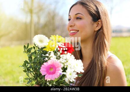 Felice bella ragazza riceve un bouquet di fiori nella Giornata Internazionale della Donna Foto Stock