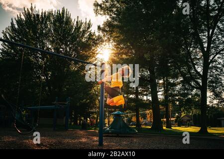 Ragazzo che oscilla su un swing in un parco, Stati Uniti Foto Stock