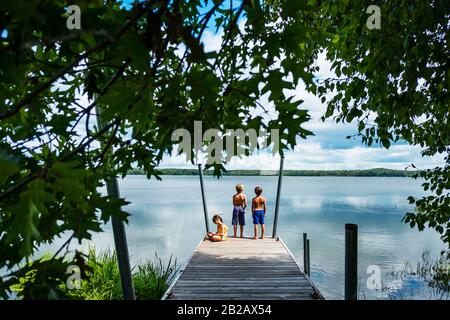 Tre bambini su un molo di pesca, Stati Uniti Foto Stock
