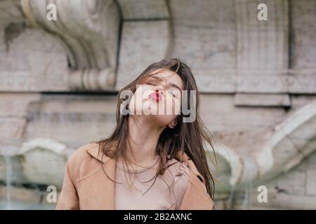 Donna che puckering in su e soffia un bacio, Roma, Lazio, Italia Foto Stock