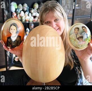 28 febbraio 2020, Sassonia, Lipsia: Il collezionista e l'artista dell'uovo di Pasqua Kerstin Dischereit si trova nel suo appartamento a Lipsia con un uovo di legno di 35 centimetri (M) e due uova di struzzo dipinte da pittori hobbisti di Lipsia (l) e Belgio (r). Kerstin Dischereit ha raccolto circa 5000 uova di Pasqua da tutto il mondo, alcuni di loro insolitamente sagomato, da uova di struzzo 12-17 centimetri di dimensioni, uova di emu 13 centimetri di dimensioni, uova di anatra 9 centimetri di dimensioni e uova di lumaca di pochi millimetri di dimensioni. Il calliografo addestrato è stato conosciuto come un artista di uovo esso stesso per oltre 20 anni, ha Foto Stock