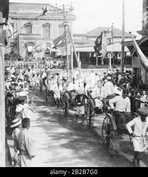 I soldati giapponesi leggermente feriti vengono tirati in carri attraverso una strada fiancheggiata da persone in un vicino ospedale militare. Foto Stock