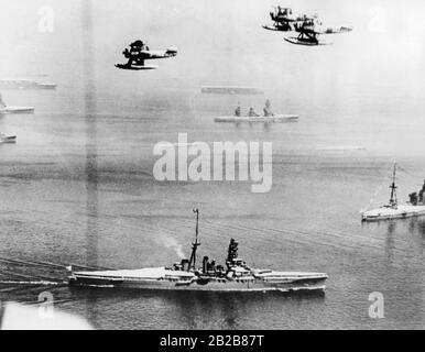 Vista sul mare vicino a Yokohama in Giappone durante una sfilata della Marina Imperiale Giapponese il 28 agosto 1939. In primo piano ci sono diversi cacciatorpediniere della Marina e aerei che volano sopra. In background nella nebbia sono due vettori aerei. Foto Stock