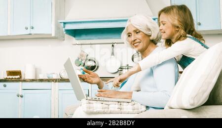 Famiglia Simpatica Granny E Little Girl Con Laptop Foto Stock