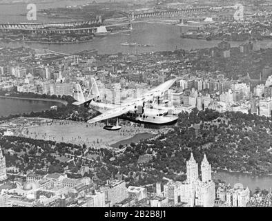 Una Sikorsky S-42 barca volante della Pan Am che vola su Manhattan. Foto Stock