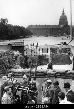 Mobilitazione in Francia nelle ultime settimane di pace prima della Seconda guerra mondiale. Nel corso della Security Exhibition, una strada completa viene ricostruita in stato di allerta. La mostra sarà aperta il 16.6.1939 a Parigi, di fronte alla Cattedrale Invaliden di Edouard Daladier. La foto mostra i civili che guardano una mitragliatrice. Sullo sfondo, la Cattedrale di Invaliden. Foto Stock