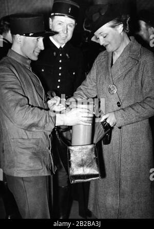 Mobilitazione in Francia nelle ultime settimane di pace prima della Seconda guerra mondiale. 200.000 maschere di gas sono state distribuite a Parigi. La fotografia mostra una donna che mette la sua maschera in un sacchetto di shopping. Foto Stock