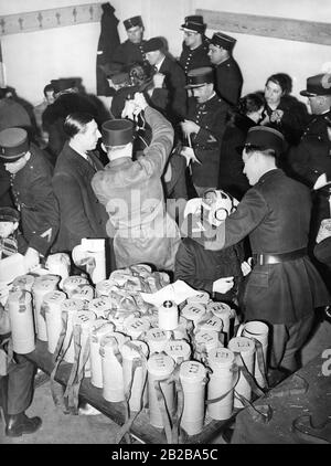 Mobilitazione in Francia nelle ultime settimane di pace prima della Seconda guerra mondiale. Le maschere a gas, che il governo francese aveva precedentemente ricevuto dalla Cecoslovacchia dopo la crisi Sudeten del settembre 1938, sono distribuite in sei arrondment parigini. Gli arcircondari sono stati scelti a caso. Nella foto una maschera a gas viene posta su un ragazzino in una stazione di distribuzione. Foto Stock