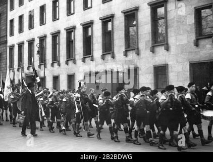 I membri della Gioventù Hitler marciano nella loro uniforme di fronte alla Cancelleria del Reich con bandiere, trombe e tamburi. Foto Stock