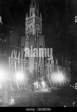 Celebrazione della Giornata dell'Arte tedesca di fronte al nuovo Municipio di Marienplatz a Monaco. Il luogo è illuminato e il municipio è decorato con bandiere. Foto Stock